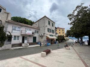 a group of people sitting outside of a building at Apartments Astoria HN in Herceg-Novi