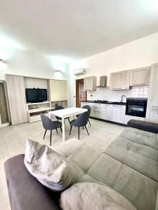 Una gran sala de estar con mesa y sillas. en AQUAMARE San Teodoro, en San Teodoro