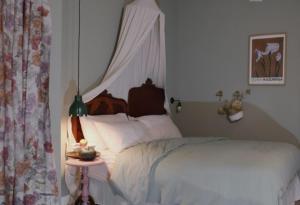 a bedroom with a white bed and a side table at Casa Fellin 1891 B&B in Cles