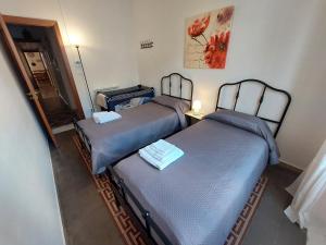 2 łóżka pojedyncze w pokoju z lustrem w obiekcie Olivuzza Apartment w mieście Palermo