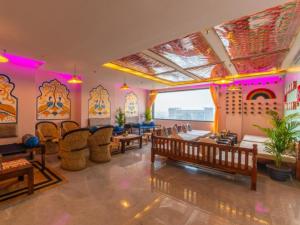 a living room with tables and chairs and a large window at The Hosteller Amritsar, Near Golden Temple in Amritsar +24 photos
