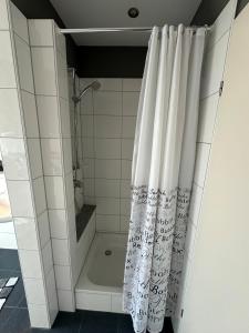 Un baño con cortina de ducha y un inodoro. en Oase für Reisende & Geschäftsleute, en Meerbusch
