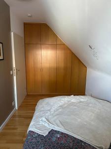 Un dormitorio con una cama y armarios de madera. en Oase für Reisende & Geschäftsleute, en Meerbusch