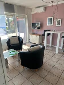 Una sala de estar con dos sillas y una mesa. en Oase für Reisende & Geschäftsleute, en Meerbusch