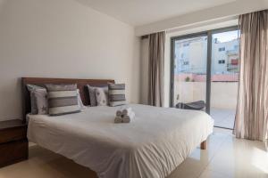 セントジュリアンズにあるVBH penthouse St Julian'sのテディベアが2体乗ったベッドのある寝室