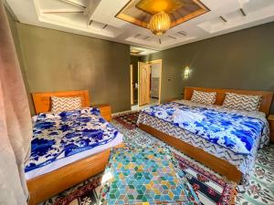 a bedroom with two beds and a chandelier at Tabourihte Gardens in Tinerhir