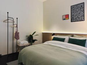 una camera da letto con un letto grande con cuscini verdi di Charming Minimal 3BR Home Near BTS Ari, Bangkok a Sathani Bang Su