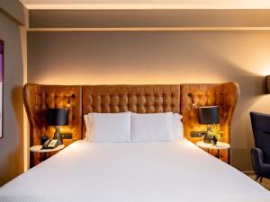 a bedroom with a large bed with two lamps at Pullman Sao Paulo Guarulhos Airport in Guarulhos