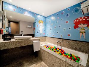 a bathroom with a tub with a sink and a mirror at Pullman Sao Paulo Guarulhos Airport in Guarulhos