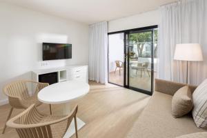 a white living room with a table and a couch at Sol Fuerteventura Jandia - All Suites in Morro del Jable