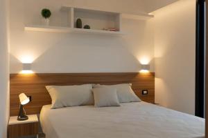 a bedroom with a white bed with a wooden headboard at Noemi's house in Padula