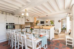une cuisine et un salon avec une table et des chaises dans l'établissement Séjour familial haut de gamme spa et confort près des plages du Débarquement, à Sommervieu