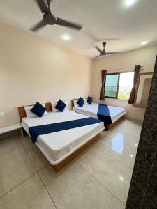 德瓦尔卡Hotel Darshan Palace - Near Dwarka Railway Station & Shree Dwarkadhish Temple的有两张床和一扇窗户的卧室