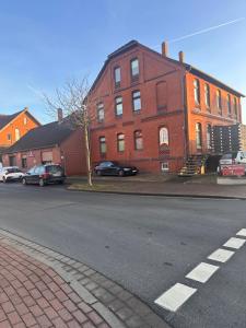 a red brick building with cars parked in front of it at Gästehaus, Robert in Nordstemmen +2 photos