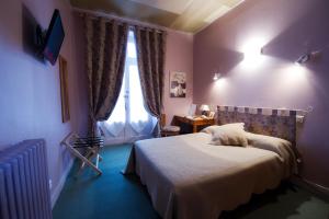 Un pat sau paturi într-o cameră la Hôtel Adour