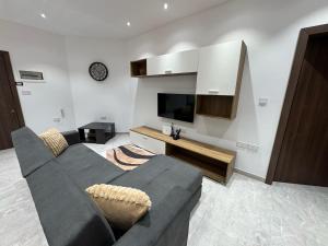 a living room with a couch and a flat screen tv at Lola Apartment in Marsaskala in Marsaskala
