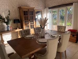 a dining room with a wooden table and chairs at Le Mas aux Papillons in Vendat