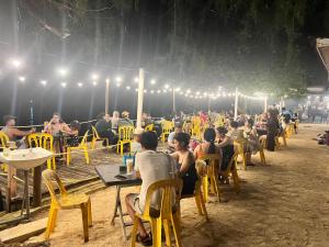 a group of people sitting at tables on the beach at Mama's Chalet Pulau Perhentian Besar in Perhentian Island