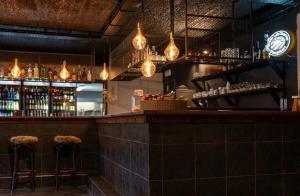 a bar with two bar stools and lights at Crossover lodge de la vallée in Durbuy