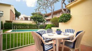 a table and chairs on a patio with a pool at Villa Nuria by HR COSTABRAVA in Platja d'Aro