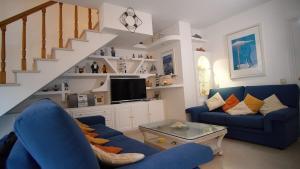 a living room with blue couches and a staircase at Villa Nuria by HR COSTABRAVA in Platja d'Aro