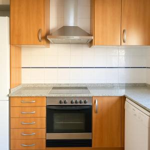 a kitchen with wooden cabinets and a stove top oven at Bellamar tonwhouse in Alcalá de Chivert