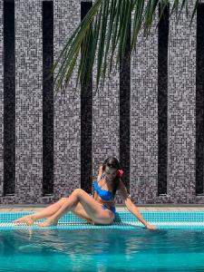 a woman laying in the water in a swimming pool at Wings by Hawks Hotels Kamadhoo Baa Atoll in Kamadhoo