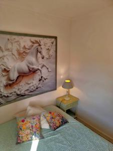 Un dormitorio con una cama con un cuadro en la pared. en Aquedarte, en Lisboa