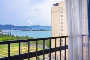 Un balcón con vista a un cuerpo de agua. en SanYa Summer Seaview Hotel, en Sanya