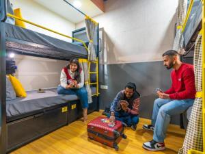 a group of people sitting in a dorm room at The Hosteller Amritsar, Near Golden Temple in Amritsar