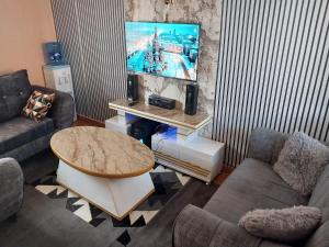 ThikaにあるUnique Place 1 Bedroom Thikaのテレビとテーブルのあるリビングルーム