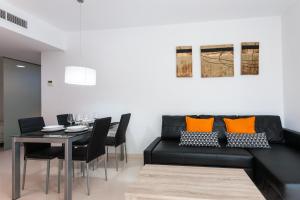 a living room with a black couch and a table at My Loft 4 You Na Jordana in Valencia