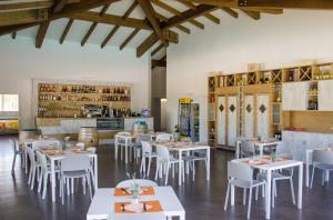 a dining room with white tables and white chairs at Camping Trasimeno in Passignano sul Trasimeno