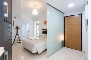 1 dormitorio con 1 cama y pared de cristal en My Loft 4 You Na Jordana, en Valencia