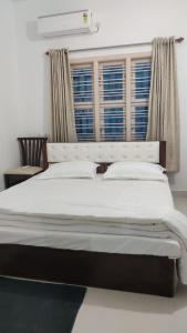 ein großes Bett in einem Zimmer mit Fenster in der Unterkunft Hill View Residence in Sringeri