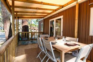 una mesa de madera y sillas en una terraza en Luma Lodge, en Seignosse