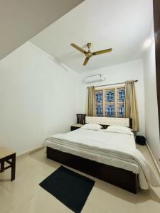 ein Schlafzimmer mit Bett und Deckenventilator in der Unterkunft Hill View Residence in Sringeri