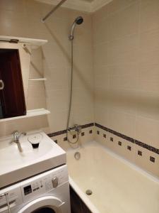 a bathroom with a tub and a sink and a washing machine at FourSpace in Ventspils +13 photos