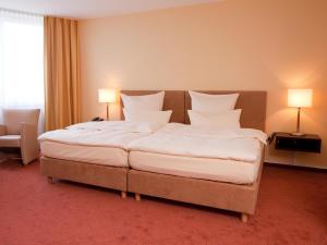Postel nebo postele na pokoji v ubytování Carathotel Basel/Weil am Rhein