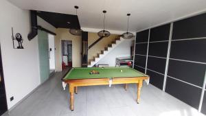 a room with a pool table and a staircase at Les Pieds dans Thau in Marseillan