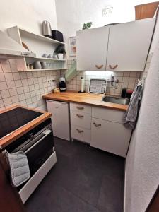 a small kitchen with white cabinets and a sink at Apartment Kleine Auszeit Kadenbach in Kadenbach