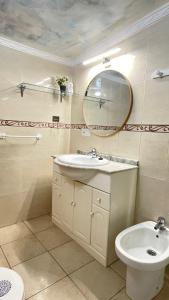 a bathroom with a sink and a mirror and a toilet at casa rústica Ronda in Ronda
