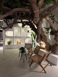 a room with two chairs and a table and a tree at Apollon Boutique Hotel in Parikia
