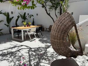 a patio with a table and a rattan hanging chair at Apollon Boutique Hotel in Parikia