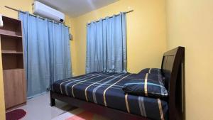 a bedroom with a bed with blue drapes at House of DHESSA in Butuan