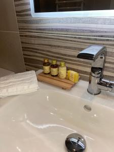 a bathroom sink with three jars on a counter at The North Cove, 20m to the Sea, Modern Studio Apartment in Portrush