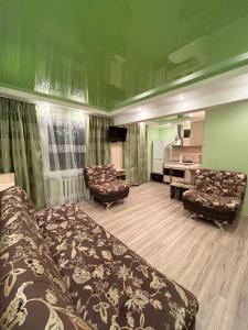 a living room with a couch and a desk at 1-комнатная на Алимжанова in Balqash