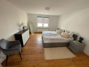 a bedroom with a bed and a chair and a window at Trebelsee 2 Monteur- und Ferienwohnung in Ketzin