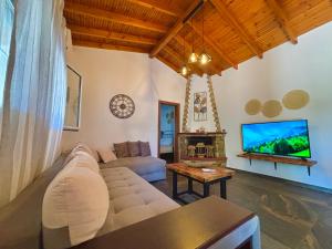 a living room with a couch and a tv at MK Rustic Stays in Neos Marmaras