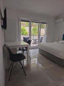 a bedroom with a bed and a desk and chairs at Villa Dian in Neum